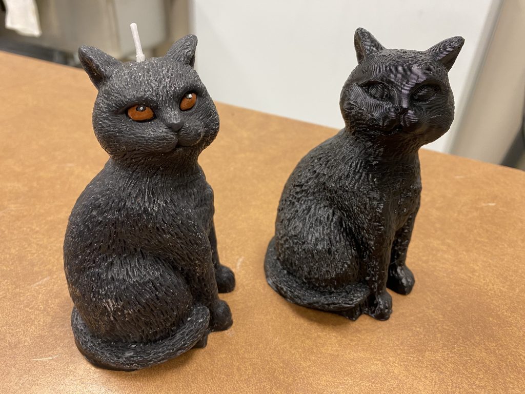 3D printed cat figurine compared to original cat candle