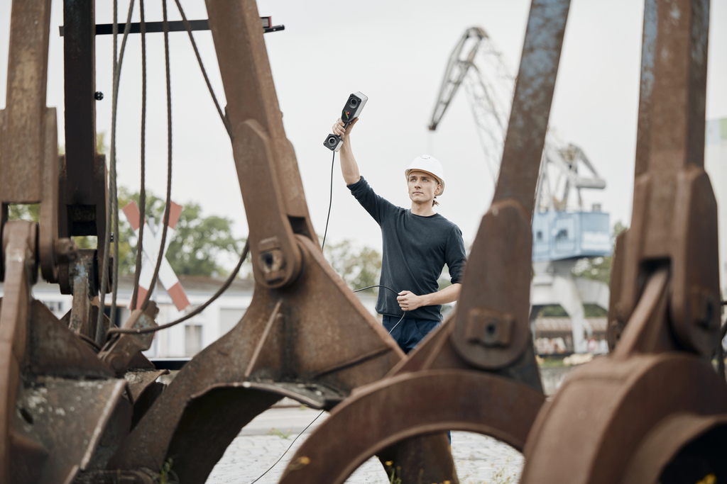 Technician uses T-SCAN hawk 2 to scan a large gripper arm