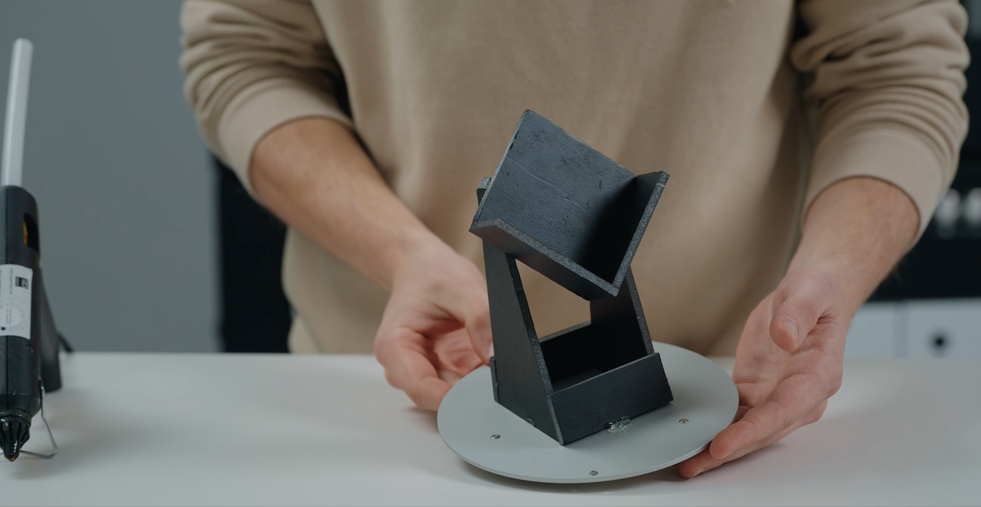 A man holding a fixturing plate with a part fixture on it
