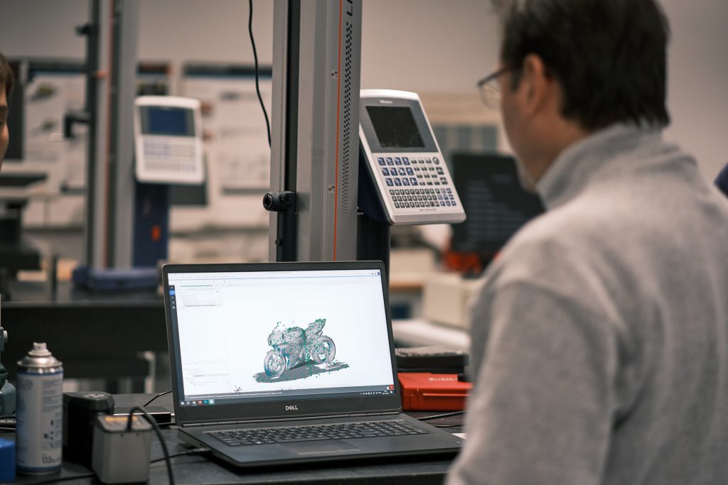 A man inspecting a 3D scan of a motorcycle in the ZEISS INSPECT software