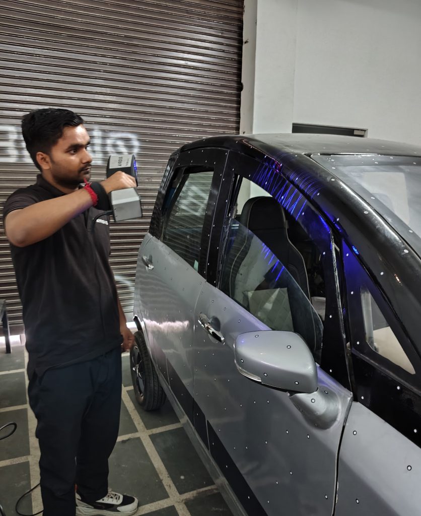 A man using handheld 3d scanner to scan an EV