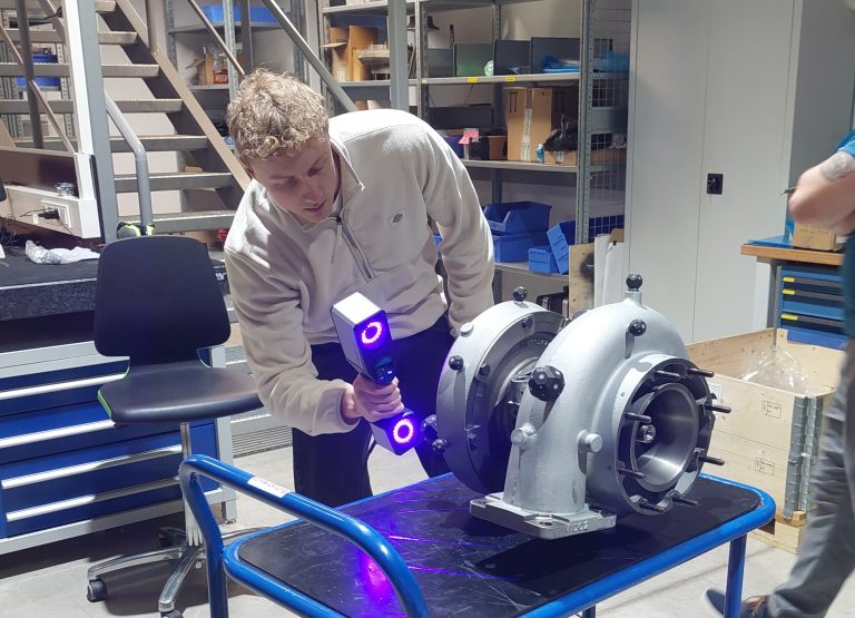 Person scanning gas engine part with hand-held 3D scanner